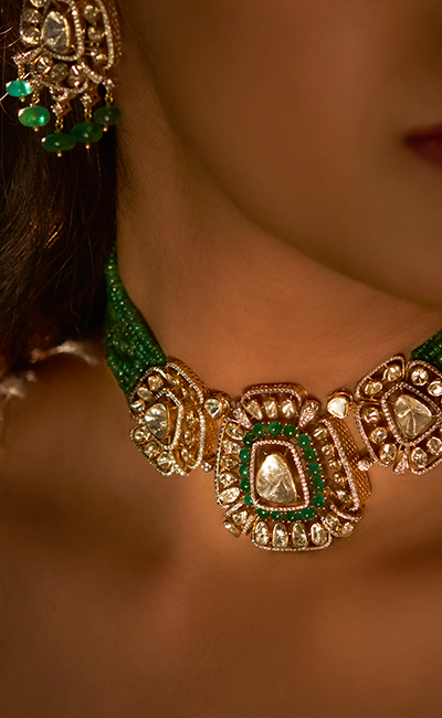 Close-up of a green and gold necklace with intricate designs.